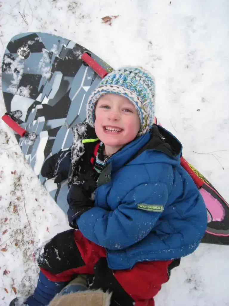 kids sledding in winter nature