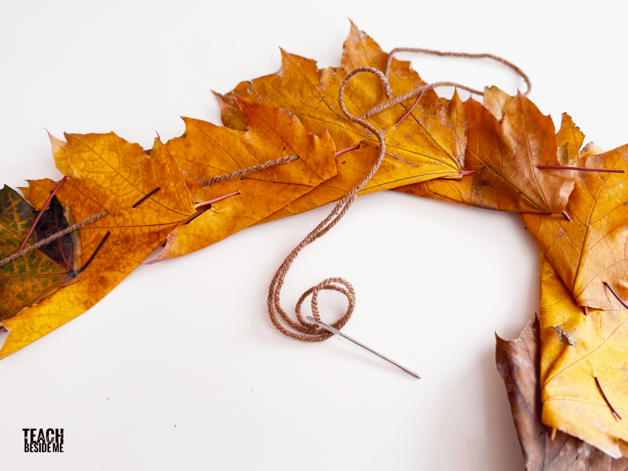 using yarn to sew leaves together for crown
